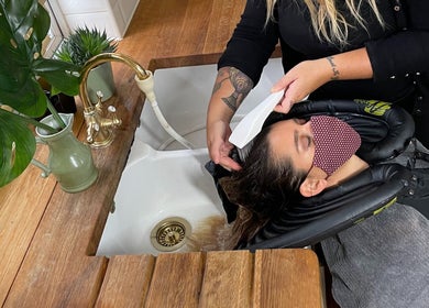 Client enjoys a hair wash at B Yo Uty Hair and Beauty Mobile Service in London, England, GB.