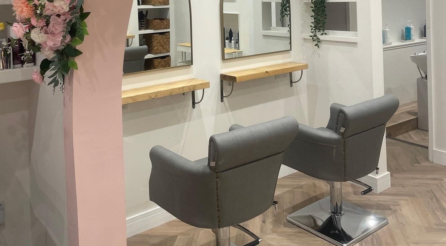 Elegant styling chairs at Amore Hair Boutique, Penarth, Wales, GB with decorative flowers and modern decor.