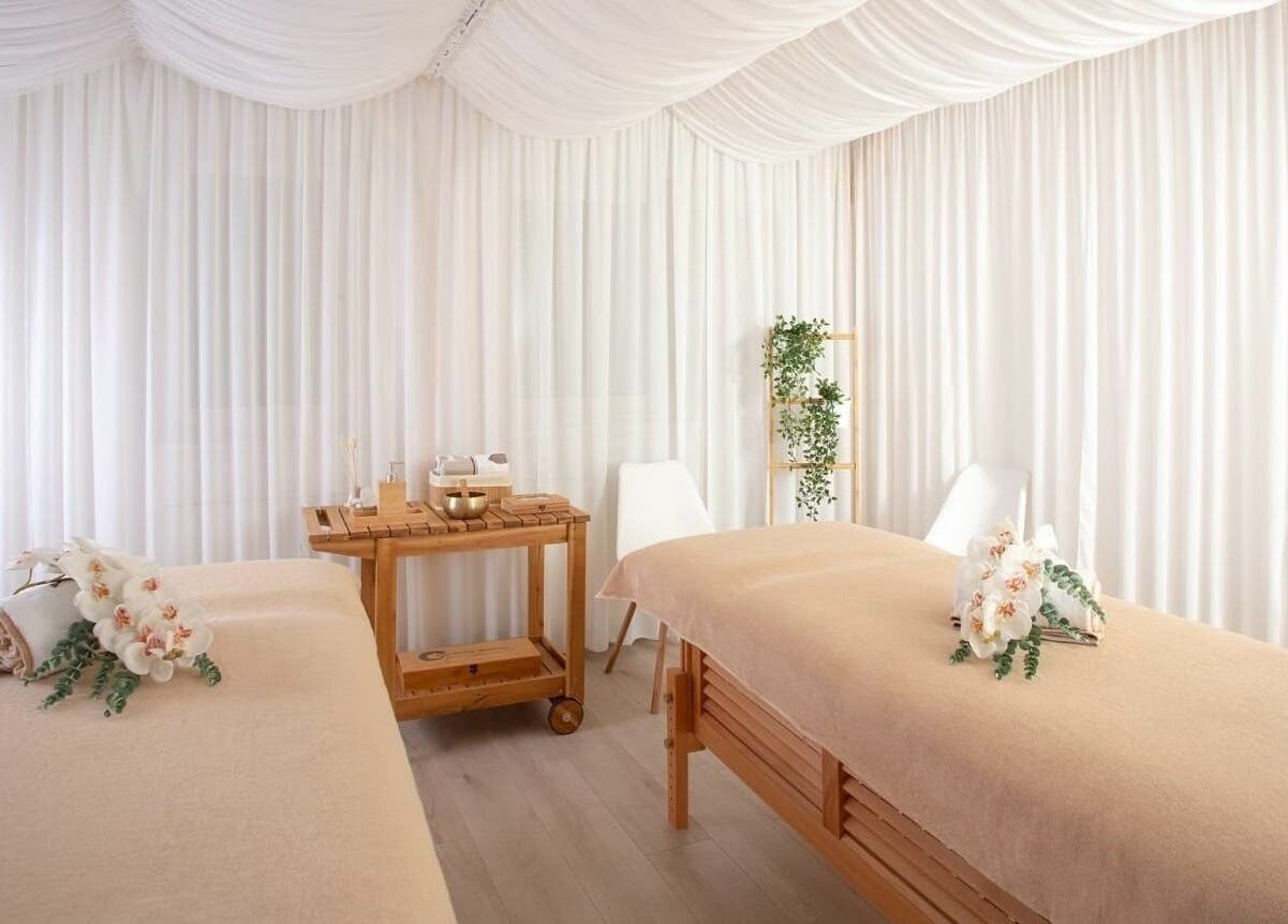 Sală de masaj elegantă la Lotus Spa Bucuresti, Bucuresti, România, RO, decorată cu flori albe și lemn natural.