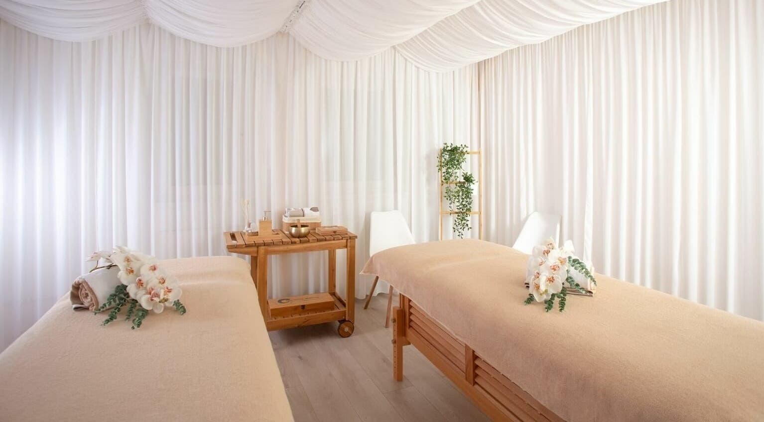 Sală de masaj elegantă la Lotus Spa Bucuresti, Bucuresti, România, RO, decorată cu flori albe și lemn natural.