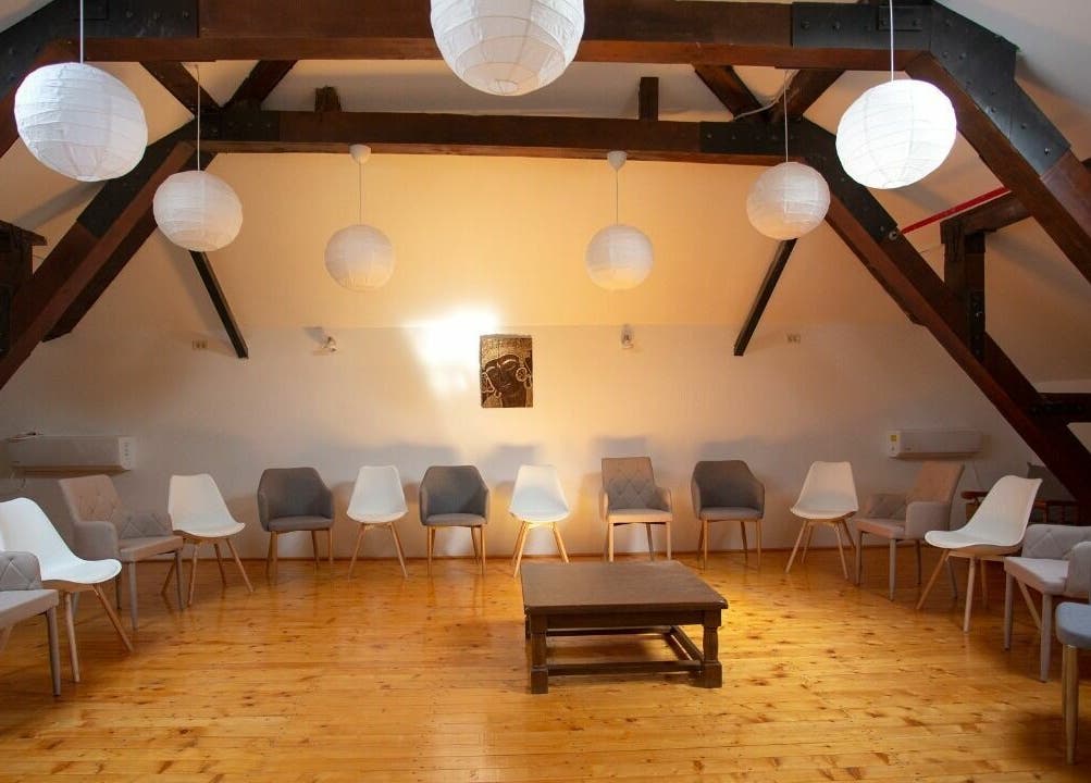 Sala de așteptare spațioasă la Lotus Spa Bucuresti, București, România, RO, cu scaune elegante sub grinzi de lemn.