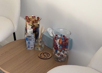 Cozy corner with chairs and table with treats at Laura J Hair Design Home Hairdresser, Cambridge Park, New South Wales, AU.