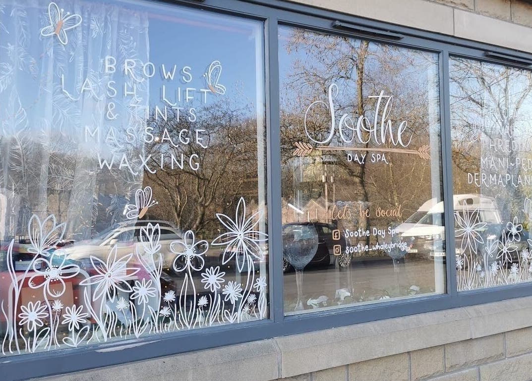 Soothe Day Spa window with floral design at Whaley Bridge, England, GB offering massages and waxing.