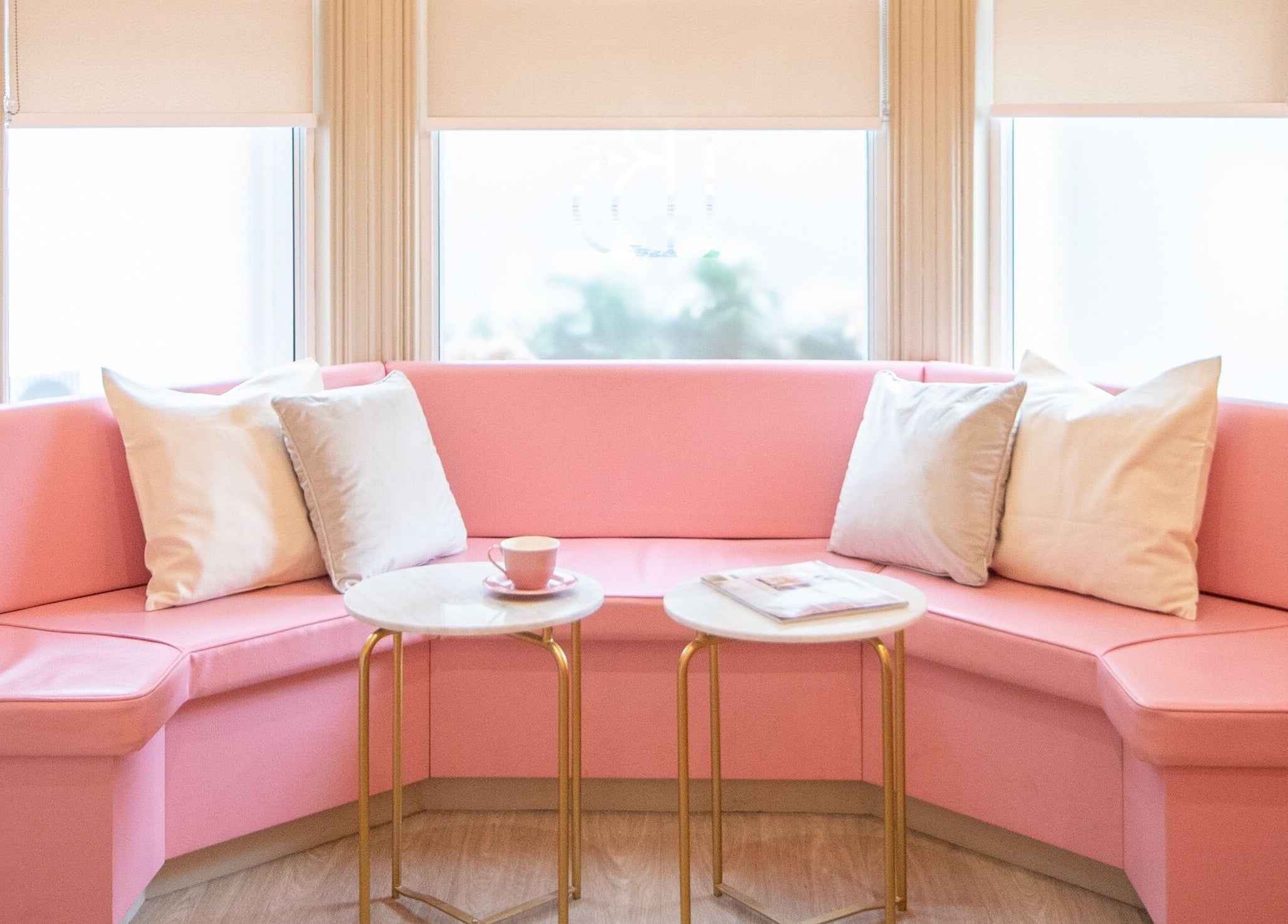 Cozy pink seating area at Beautification Nottingham, Nottingham, England, GB, with white pillows and tables.