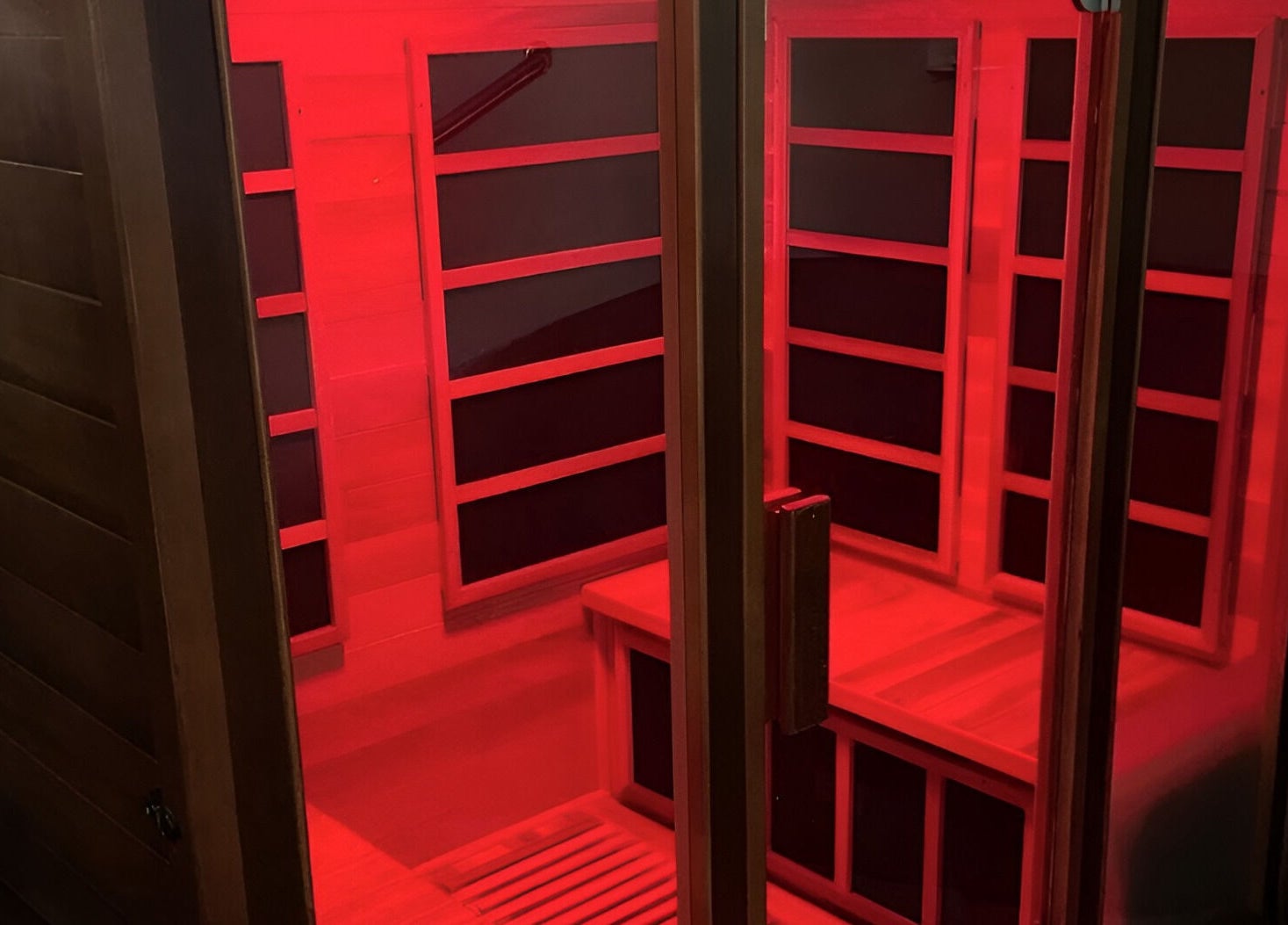Infrared sauna at Black Swan Therapy & Spa Lounge, Bognor Regis, England, GB, glowing with red light.