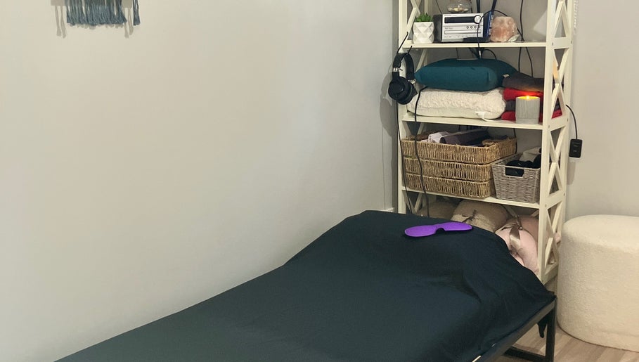 Relaxing therapy room at Altruistic Alternative Therapies, Muckatah, Victoria, AU with a cozy bed and shelves.