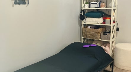 Relaxing therapy room at Altruistic Alternative Therapies, Muckatah, Victoria, AU with a cozy bed and shelves.