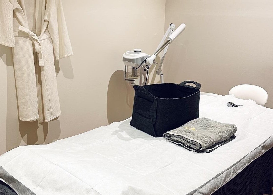 Tranquil treatment room at Five Elements Spa, South Melbourne, Victoria, AU with massage bed and bathrobe.