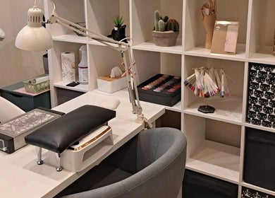 Elegant nail station at Nails & Pearls Manikīra studija, Rīga, LV, with organized shelves and manicure tools.