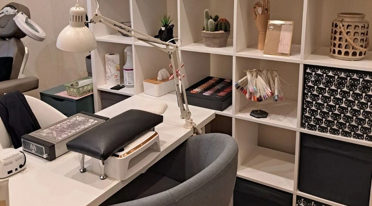 Modern manicure station at Nails & Pearls Manikīra studija, Rīga, LV, showcasing tools and nail colors.