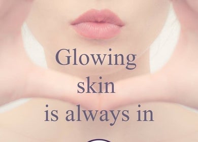 Close-up of a woman's lips with text 'Glowing skin is always in' at Bronzed Beauty, Bournemouth, England, GB.