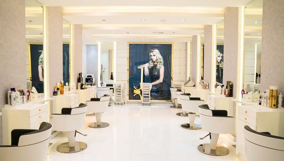Modern salon interior at Maison De Joelle- Mirdif, Dubai, AE with stylish white stations and elegant lighting.