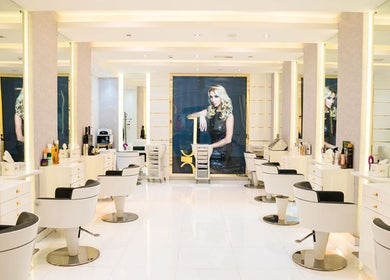 Modern salon interior at Maison De Joelle- Mirdif, Dubai, AE with stylish white stations and elegant lighting.