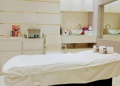Relaxing treatment room at Maison De Joelle- Mirdif, Dubai, AE, featuring a plush white bed and calming decor.