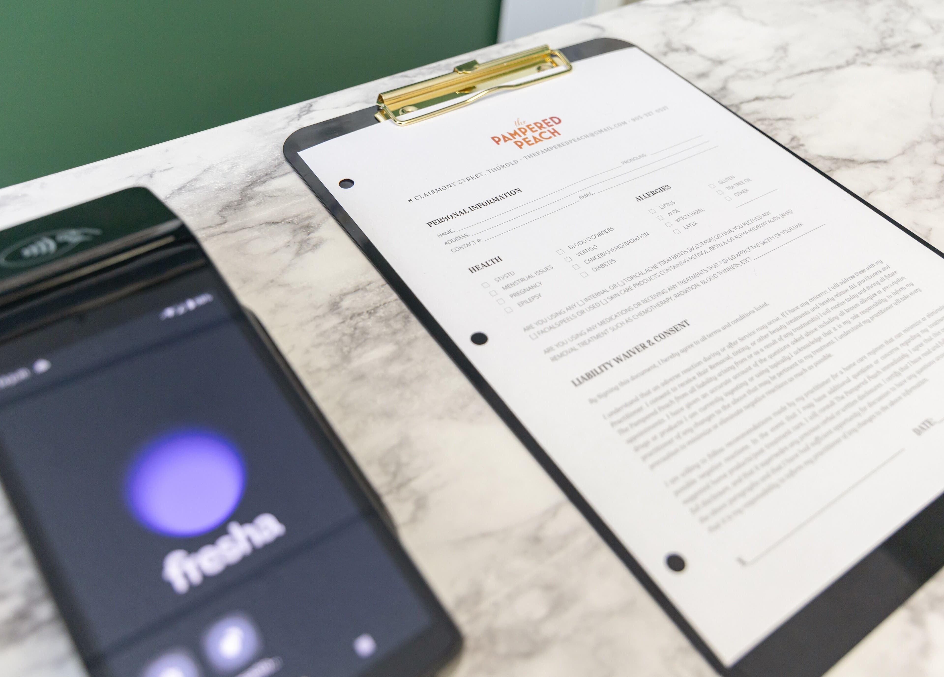 Check-in form at The Pampered Peach in Thorold, Ontario, CA on a marble counter.