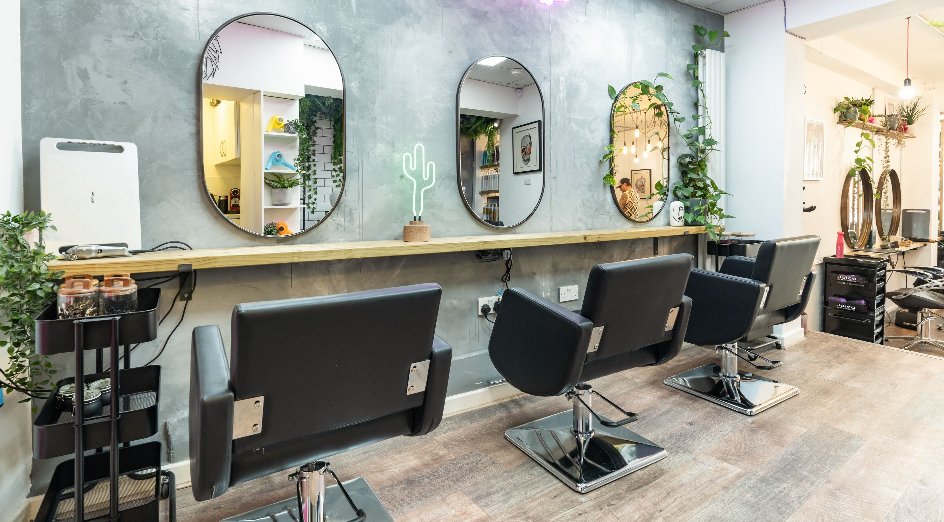 Modern salon interior at Hiley Hair Club, Cheltenham, England, GB with stylish chairs and mirrors.