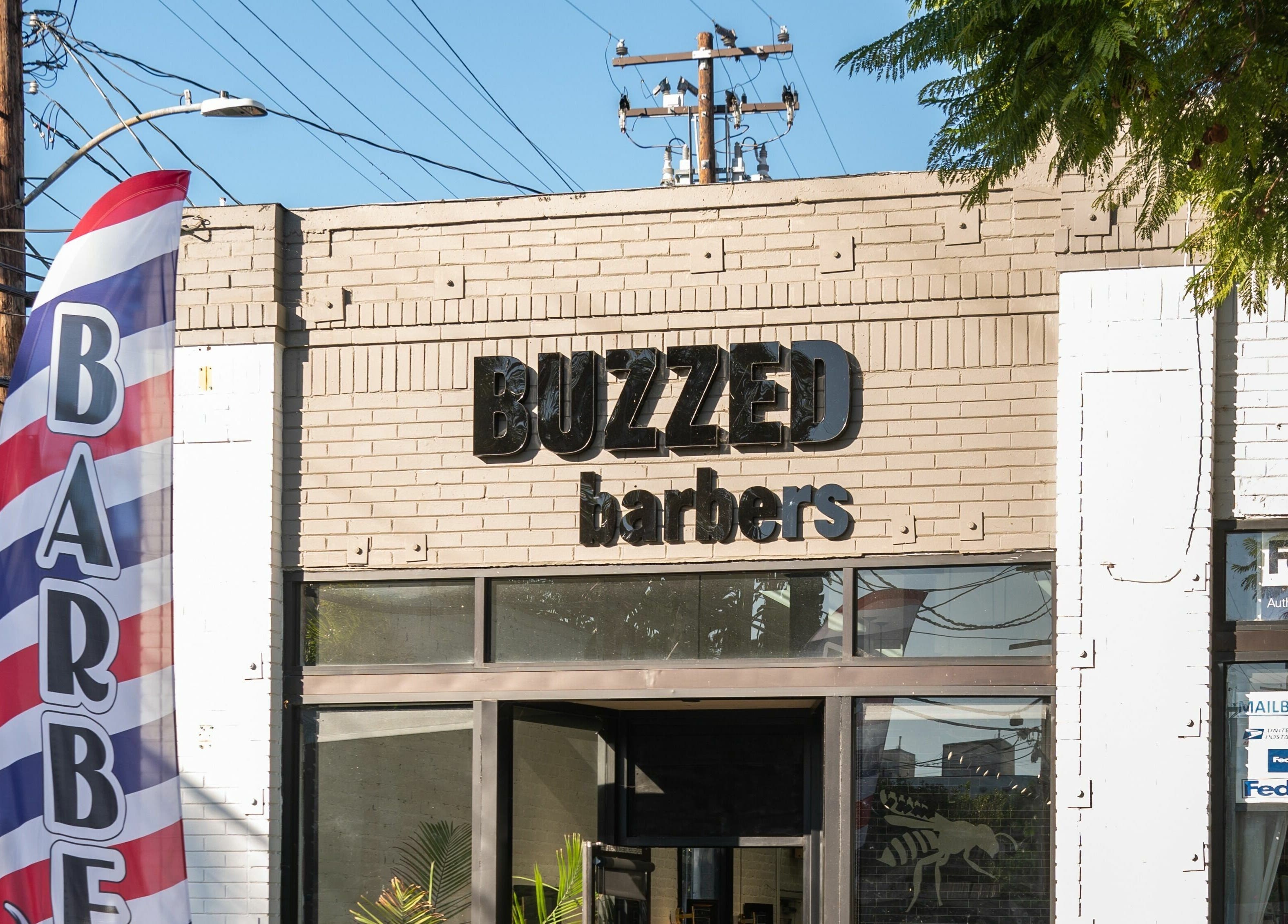 Front view of Buzzed Barbers West Hollywood in California, featuring its modern signage.