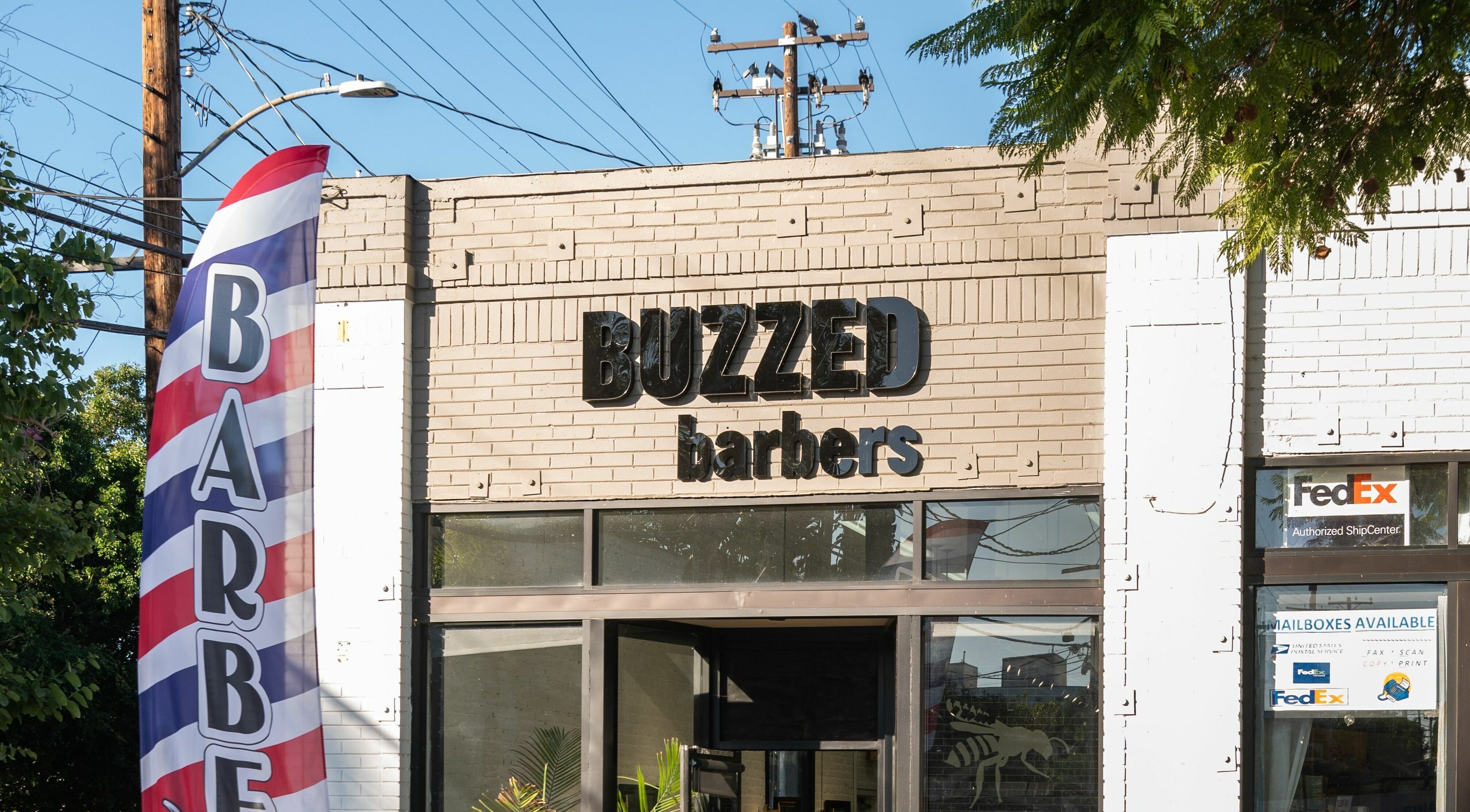 Front view of Buzzed Barbers West Hollywood in California, featuring its modern signage.