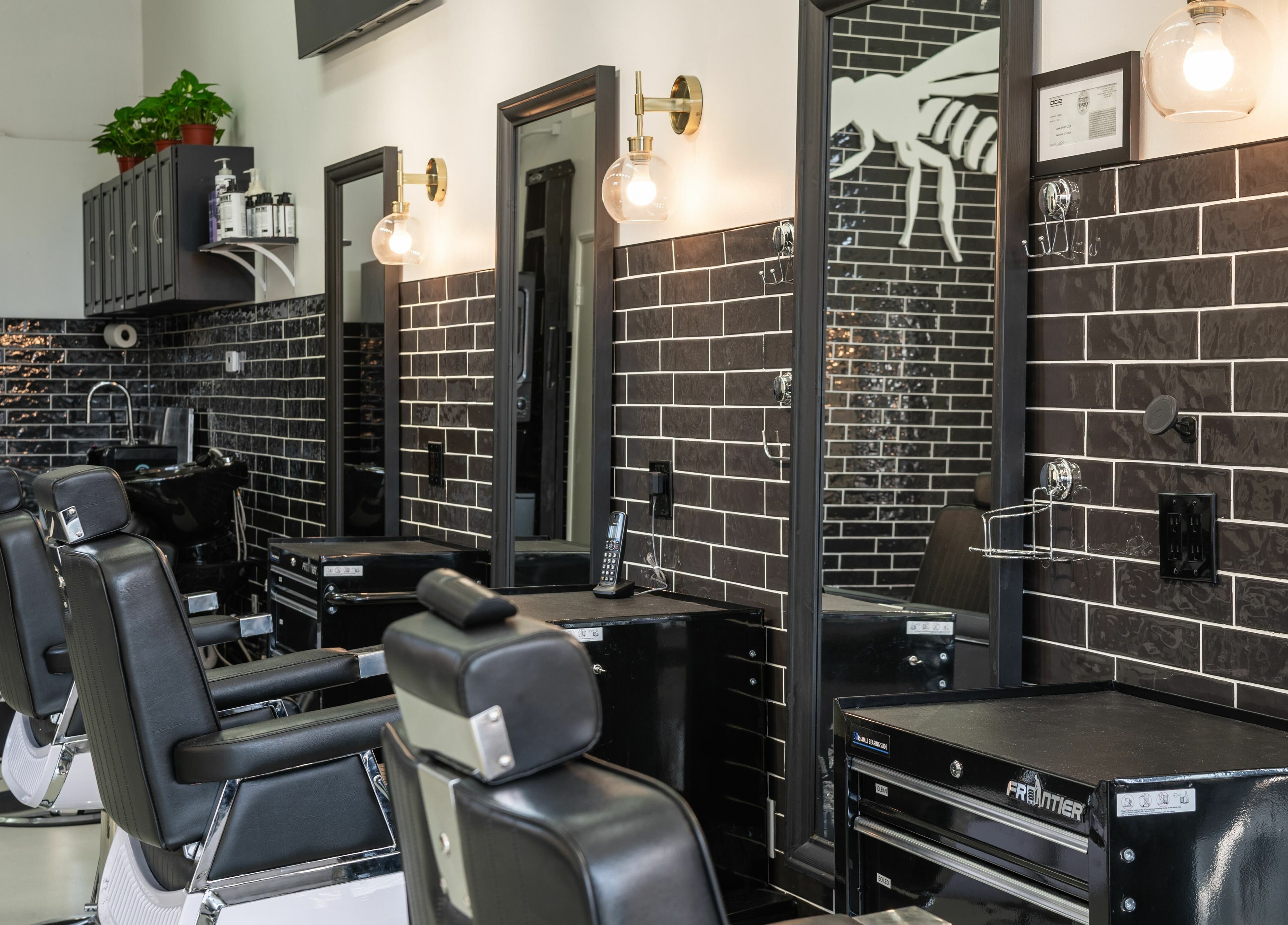 Modern barber chairs and sleek black tiles at Buzzed Barbers West Hollywood, California, US.