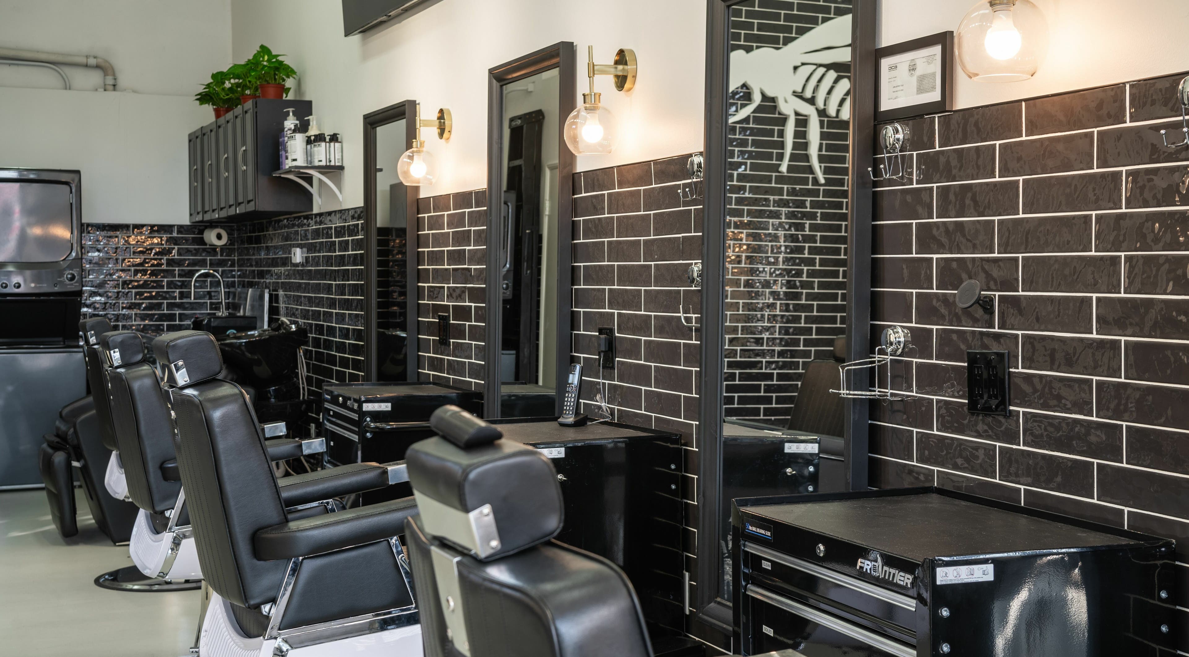 Modern barber chairs and sleek black tiles at Buzzed Barbers West Hollywood, California, US.