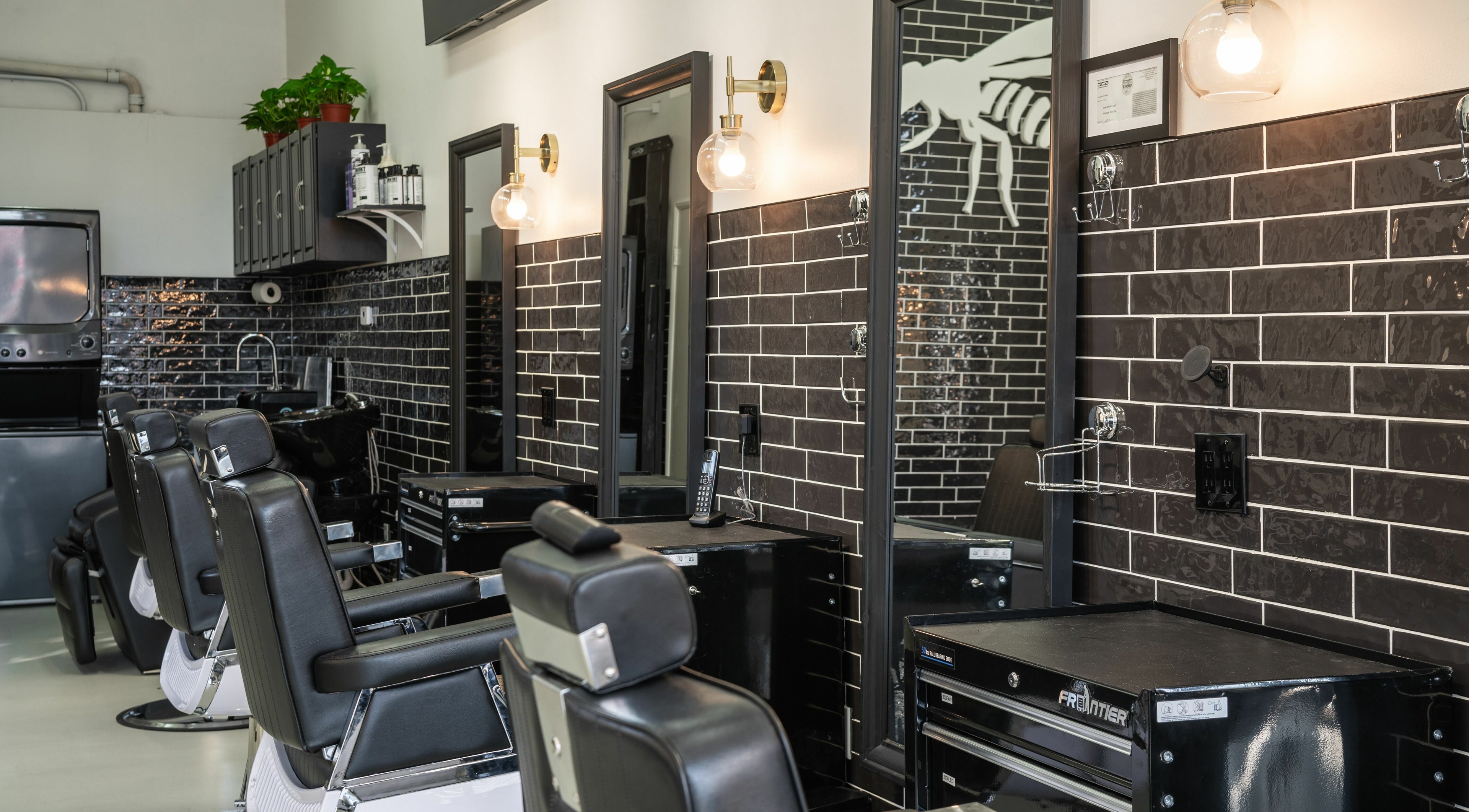 Modern barber chairs and sleek black tiles at Buzzed Barbers West Hollywood, California, US.