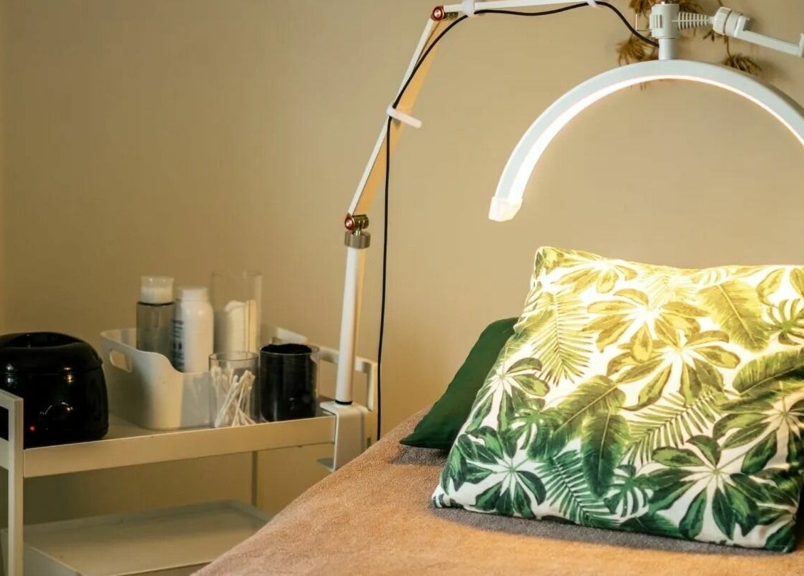 Relaxing treatment room at The Green Sanctuary, Swadlincote, England. Features a tropical-themed pillow and lamp.