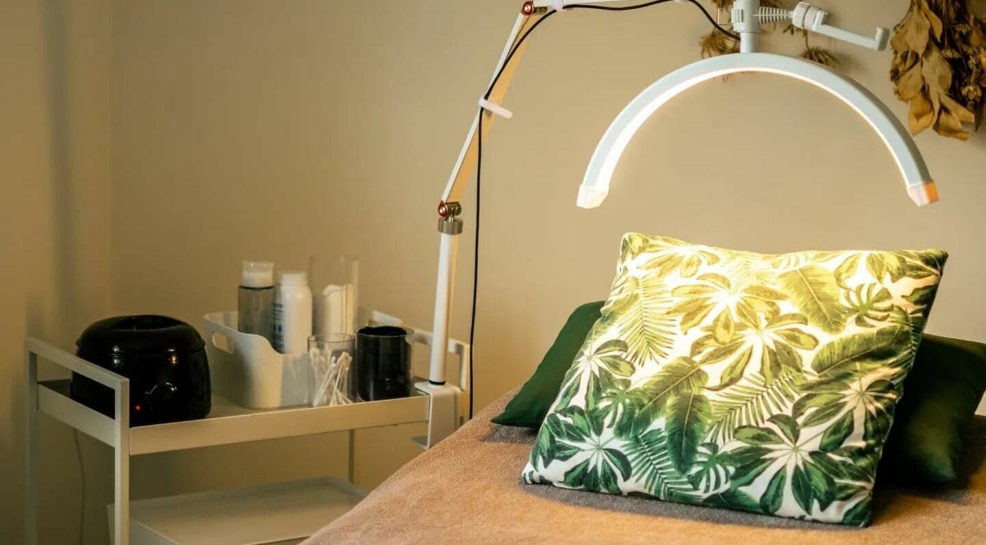 Relaxing treatment room at The Green Sanctuary, Swadlincote, England. Features a tropical-themed pillow and lamp.