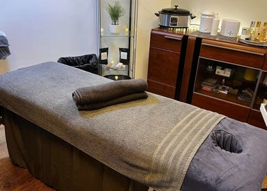 Cozy massage room at Bk's Beauty, Milton Damerel, England, GB with towels and spa equipment.
