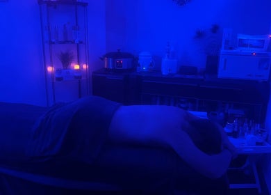 Dimly lit treatment room at Bk's Beauty, Milton Damerel, England, GB with a massage table and calming ambiance.