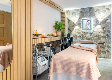 Trends Aesthetic Beauty Salon treatment room with stone walls and cozy bed, London, England, GB.