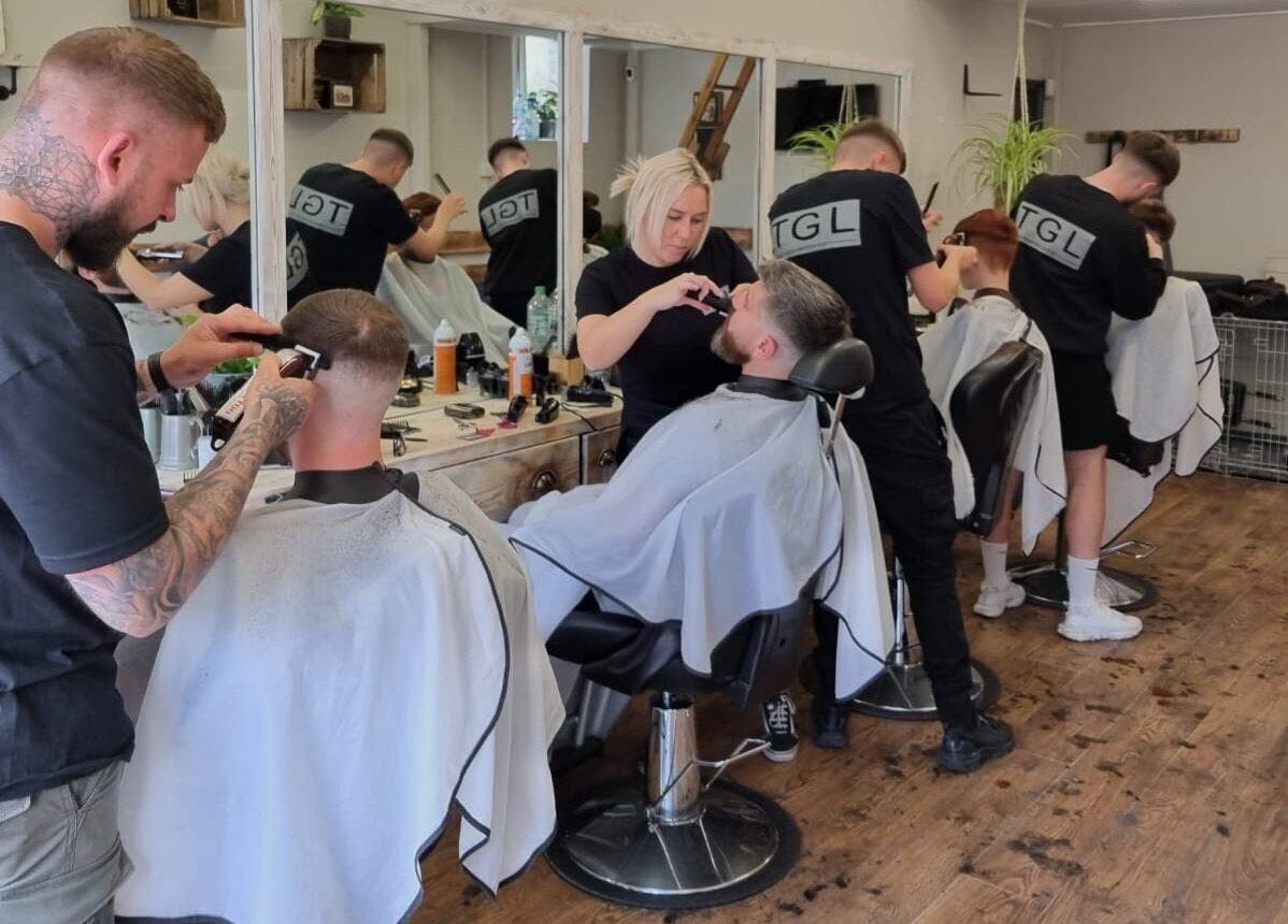 Barbers at work at The Gentlemen’s Lounge Biggleswade, England, GB providing stylish haircuts.