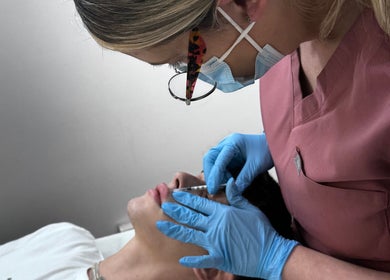 Aesthetician performing lip filler treatment at Salon Angels Beauty & Aesthetics, Caerphilly, Wales, GB.