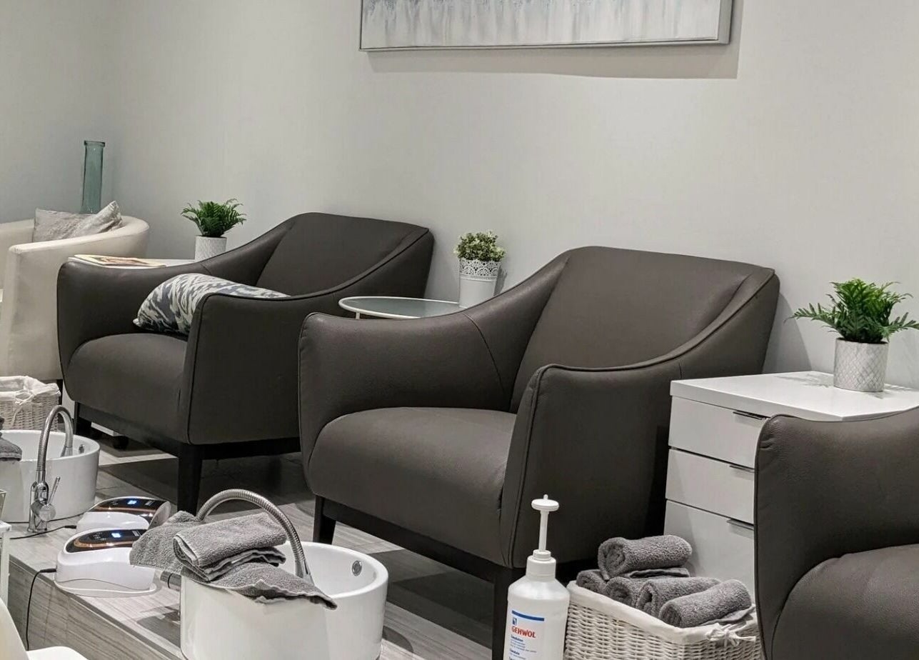 Salon élégant chez Pure Bar à Ongles and Soins, Laval, Québec, CA, avec fauteuils modernes et décor raffiné.