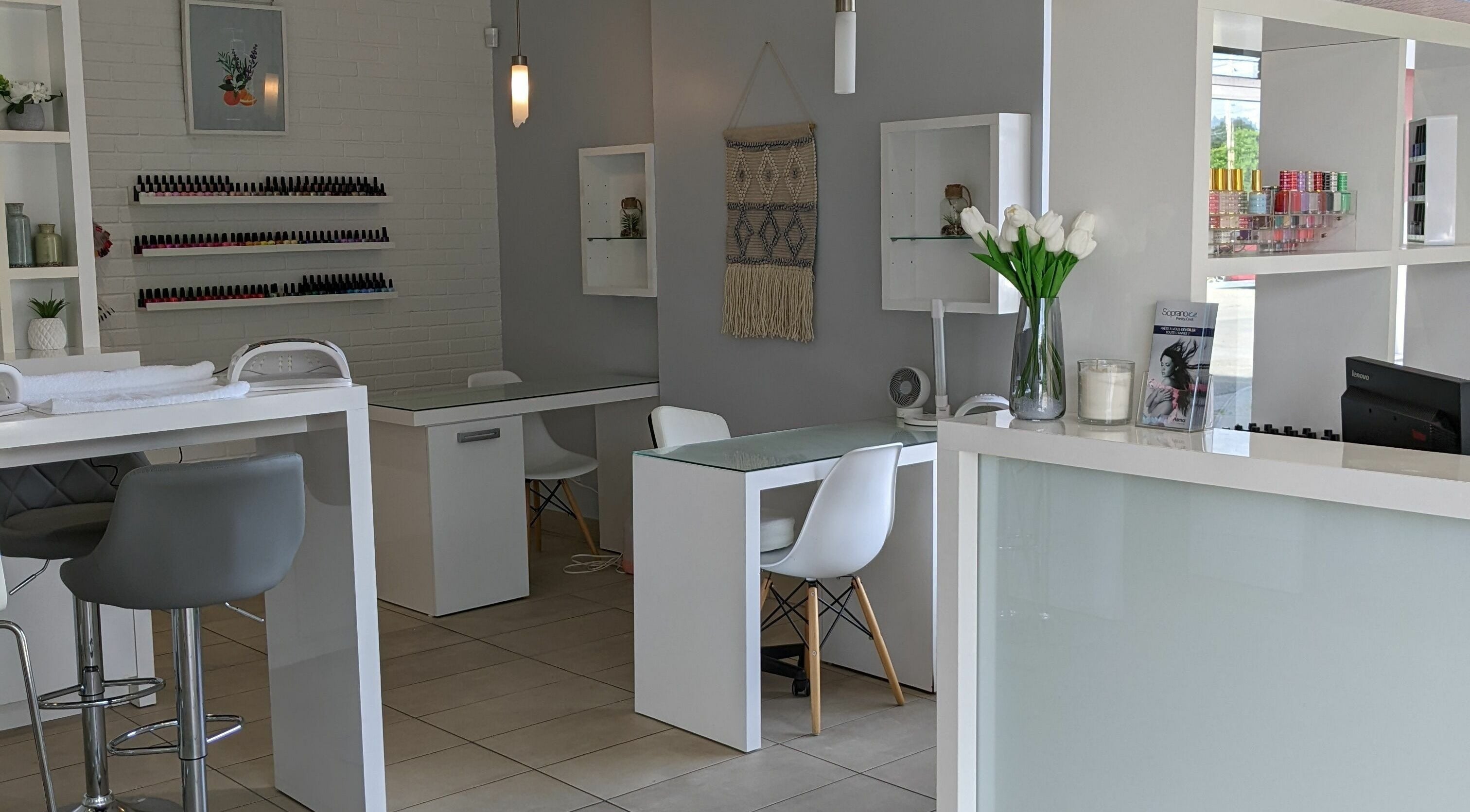 Intérieur moderne de Pure Bar à Ongles and Soins, Laval, Québec, CA, avec décor blanc élégant.