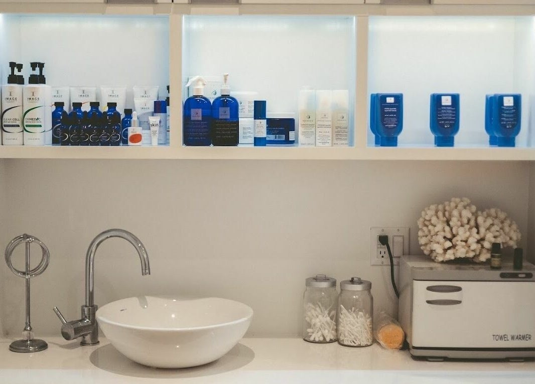 Produits de beauté chez Pure Bar à Ongles and Soins à Laval, Québec, CA, avec lavabo et chauffe-serviettes.