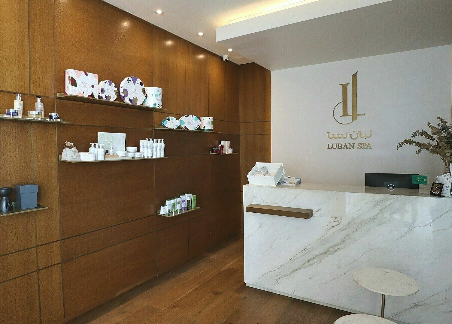 Reception area of Luban Spa in Dubai, AE showcasing luxurious product displays and modern decor.