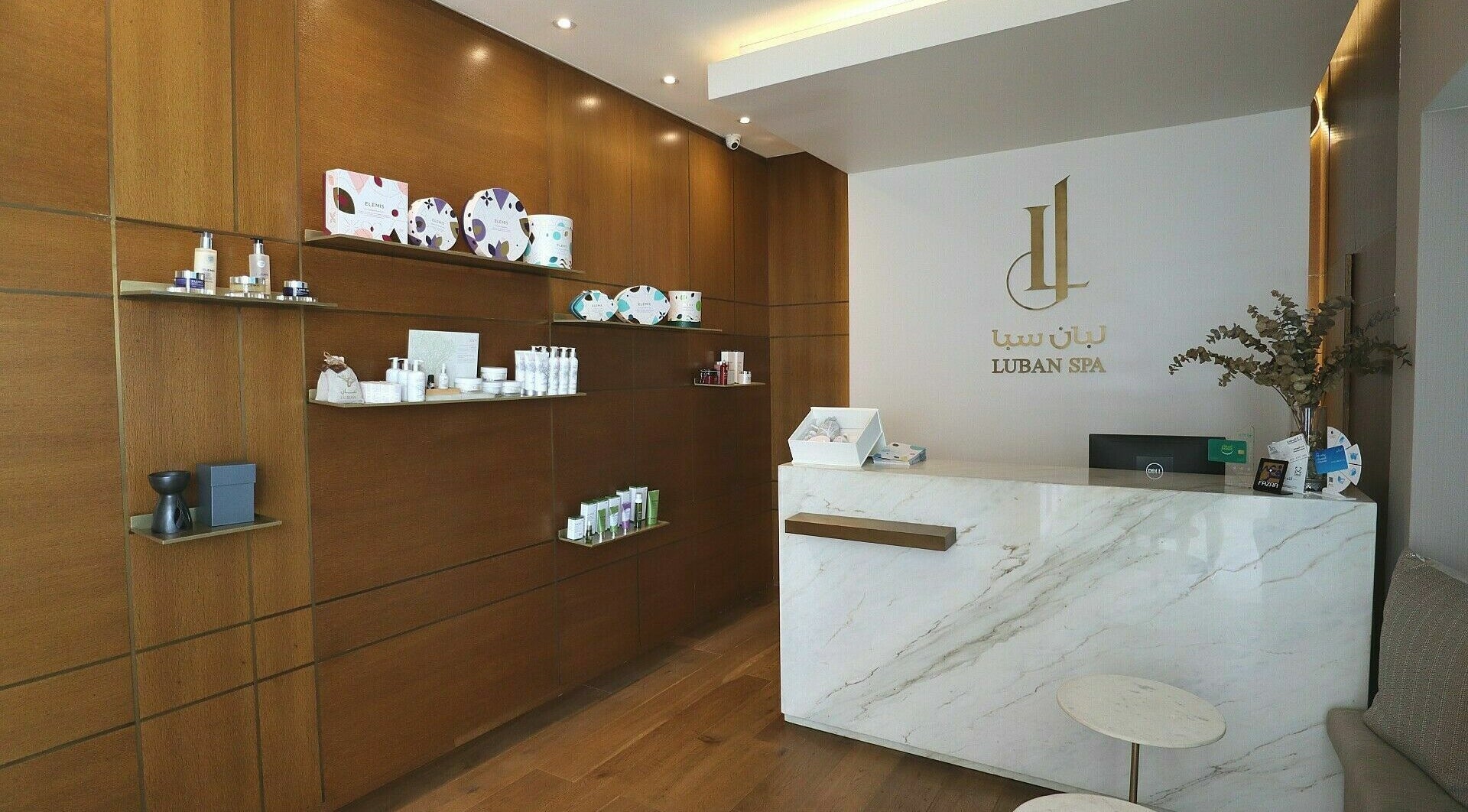 Reception area of Luban Spa in Dubai, AE showcasing luxurious product displays and modern decor.