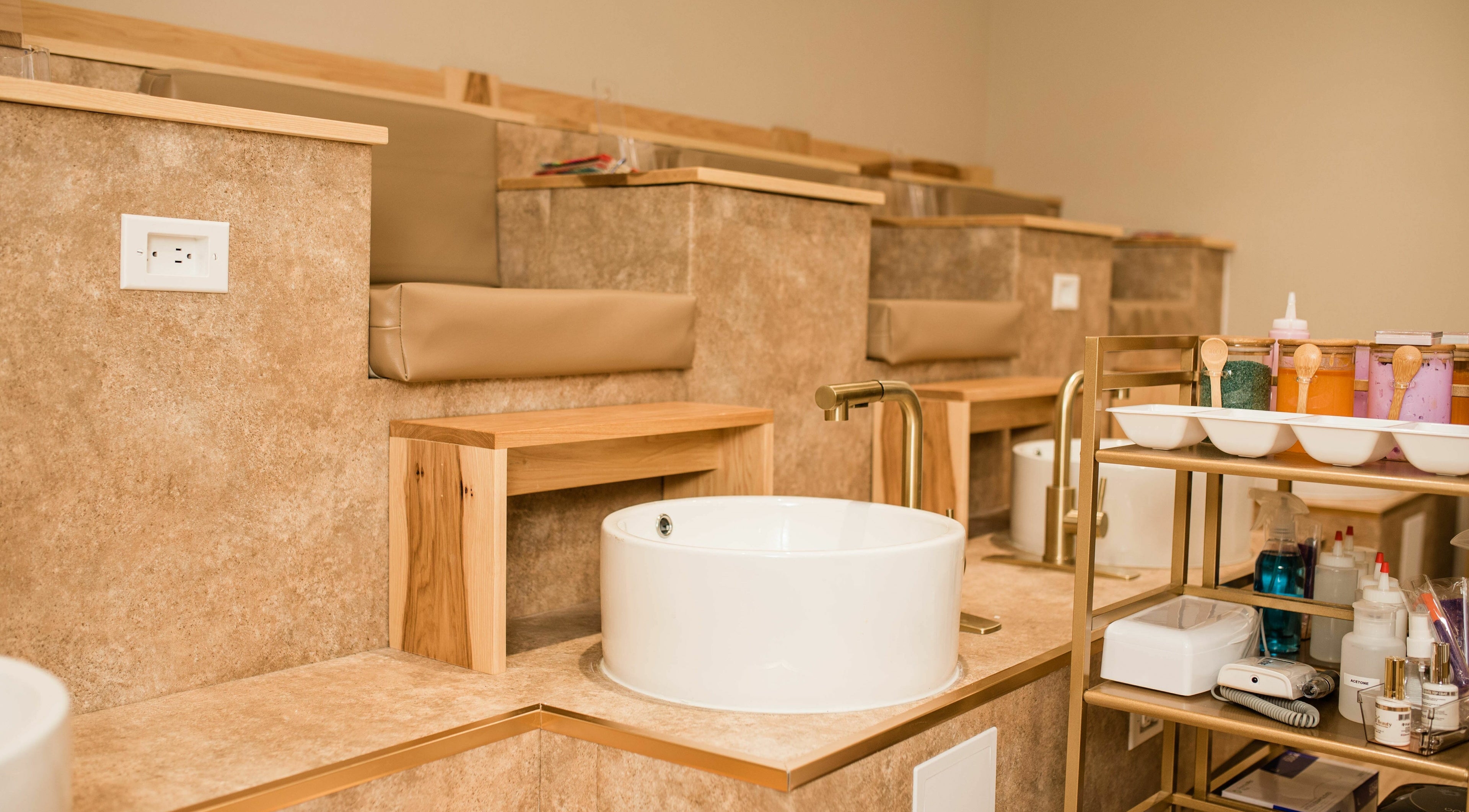 Elegant nail spa area at The Babe Kave, Flint, Michigan, US with plush seating and foot basins.