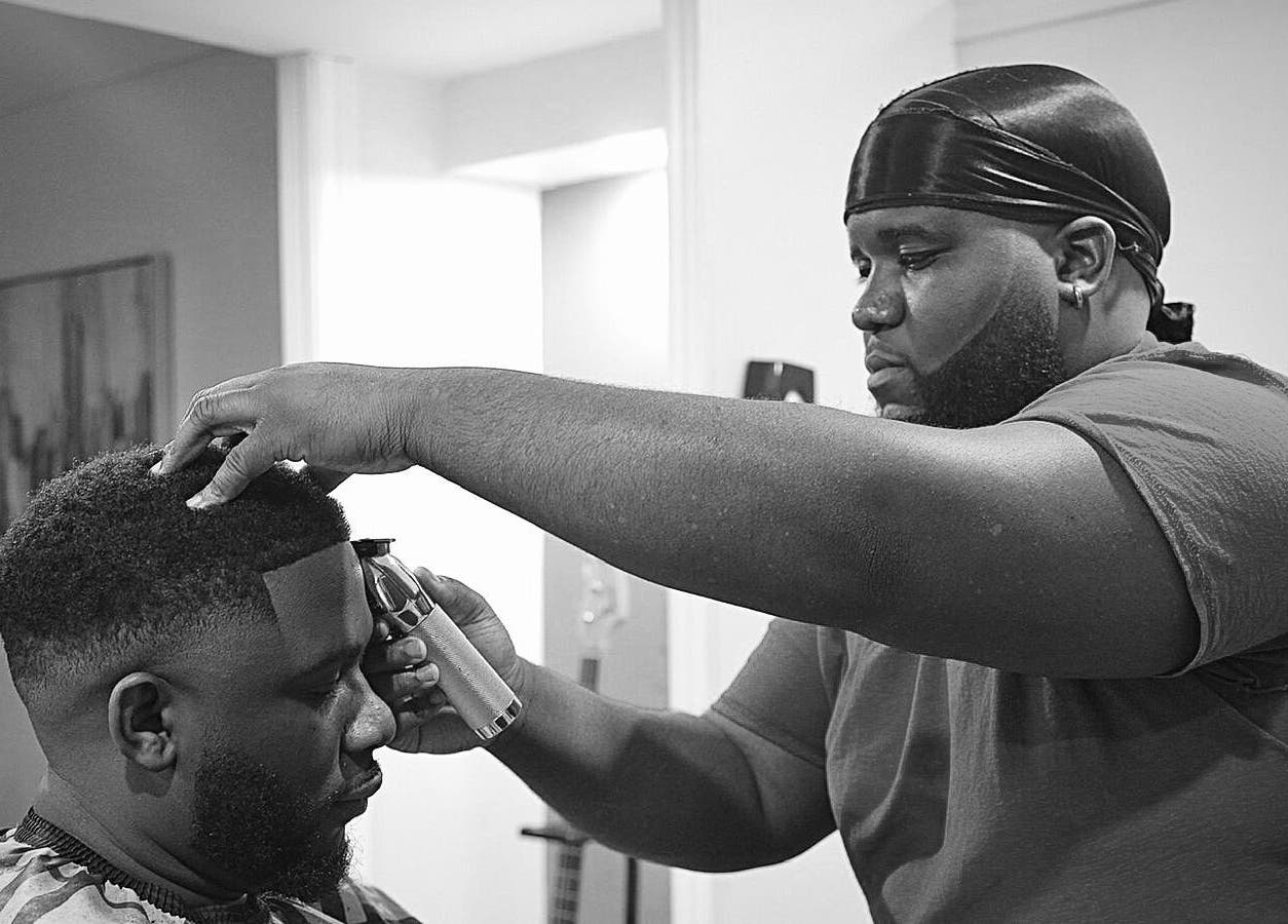 Sid the Barber expertly trims a client's hair in Oshawa, Ontario, CA, showcasing skilled grooming techniques.