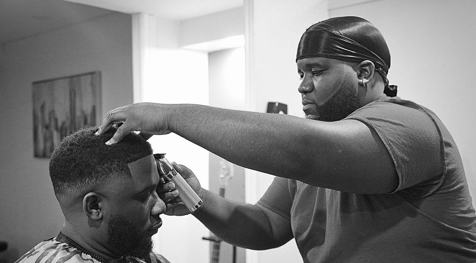 Sid the Barber expertly trims a client's hair in Oshawa, Ontario, CA, showcasing skilled grooming techniques.
