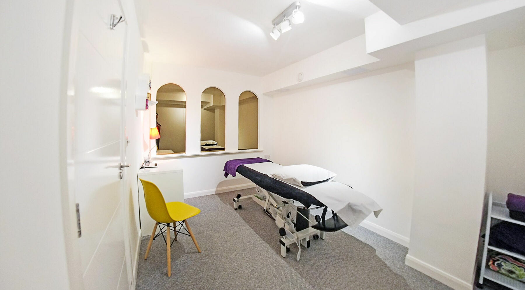 Tranquil therapy room at Equilibrium Therapy Clinic, Brighton, England, GB, featuring a massage table and chair.