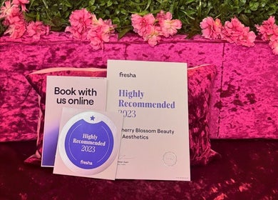 Award and booking sign at Cherry Blossom Beauty, Thornaby, England, GB on pink floral backdrop.