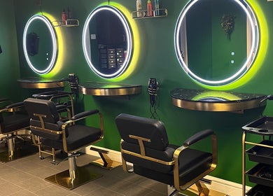 Stylish interior of Halo Hair Salon in Malton, England, GB with illuminated mirrors and black chairs.