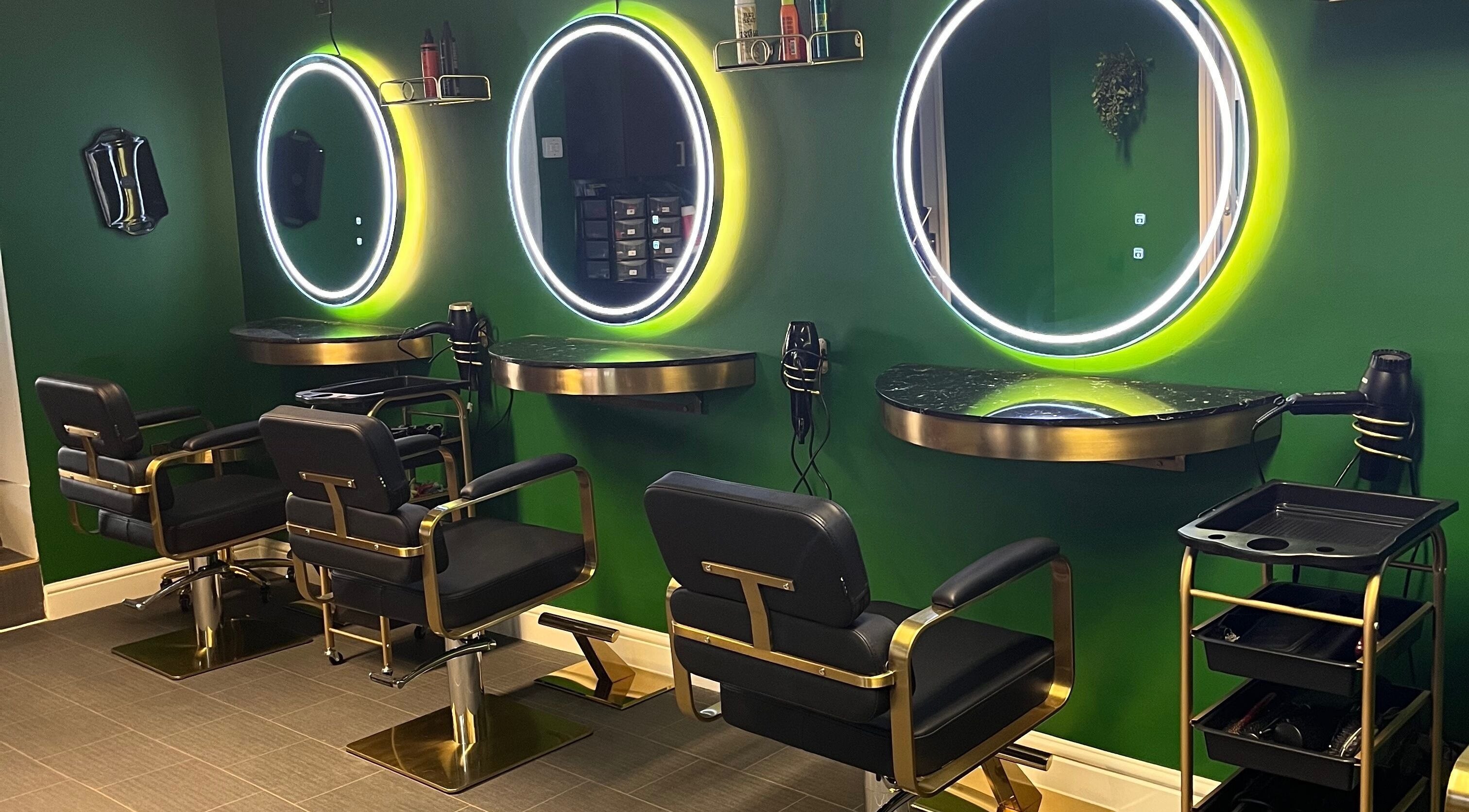 Stylish interior of Halo Hair Salon in Malton, England, GB with illuminated mirrors and black chairs.