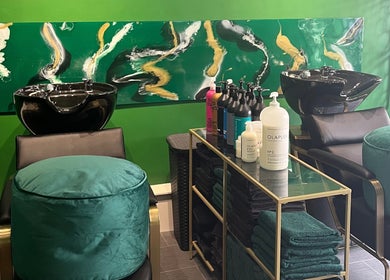 Halo Hair Salon's sleek washing area in Malton, England, GB featuring modern black basins and vibrant decor.