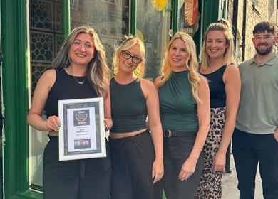 Halo Hair Salon team holds award outside salon in Malton, England, GB, showcasing their excellence.