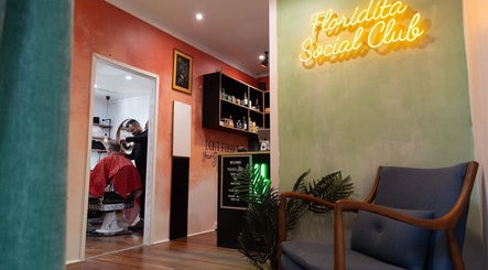 Modern interior of Empire Barbering Company in Ashgrove, Queensland, AU with a barber at work in the stylish salon.