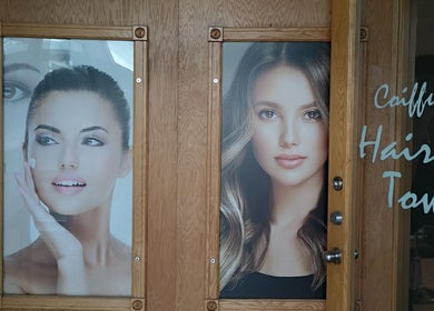 Affiches beauté à l'entrée de Hair Town, Mont-Royal, Québec, CA, montrant des visages élégants.