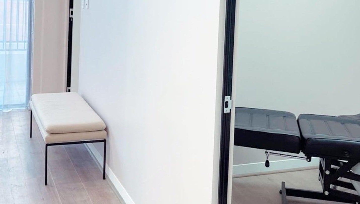 A tranquil treatment room at Haus of Arches, Bicton, Western Australia, AU with a massage table and seating.