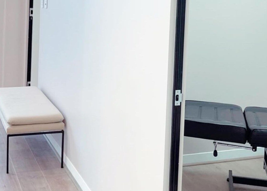 A tranquil treatment room at Haus of Arches, Bicton, Western Australia, AU with a massage table and seating.